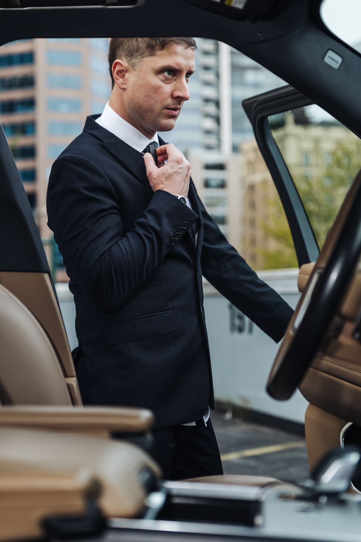 MI8 executive protection officer beside a Range Rover in downtown Vancouver